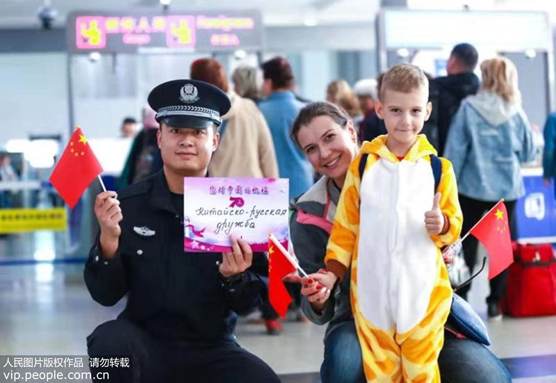 满洲里出入境边防检查干警与俄籍旅客共话祝福合影。