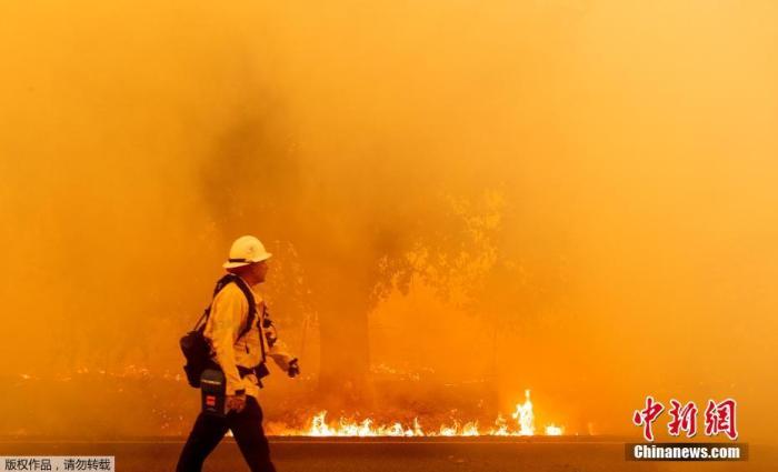 当地时间2020年8月19日，美国加利福尼亚州瓦卡维尔，野火蔓延致房屋树木被毁，出现罕见火龙卷现象。图为山火肆虐，消防人员在火灾现场。